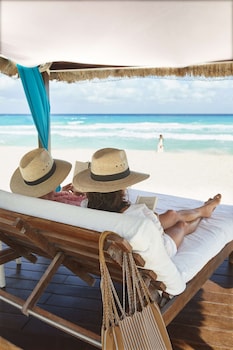 On the beach, white sand, beach cabanas, sun loungers